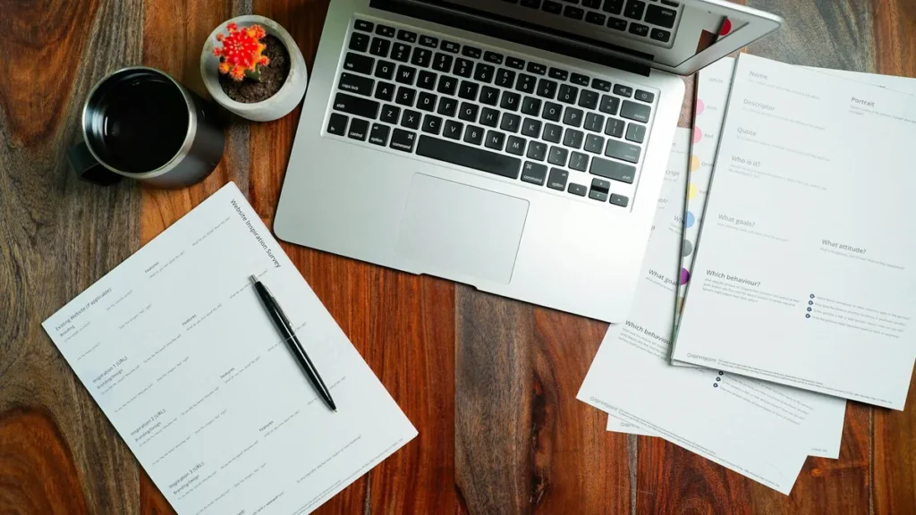 Laptop and paperwork on an office desk for reviewing a worker's employment status