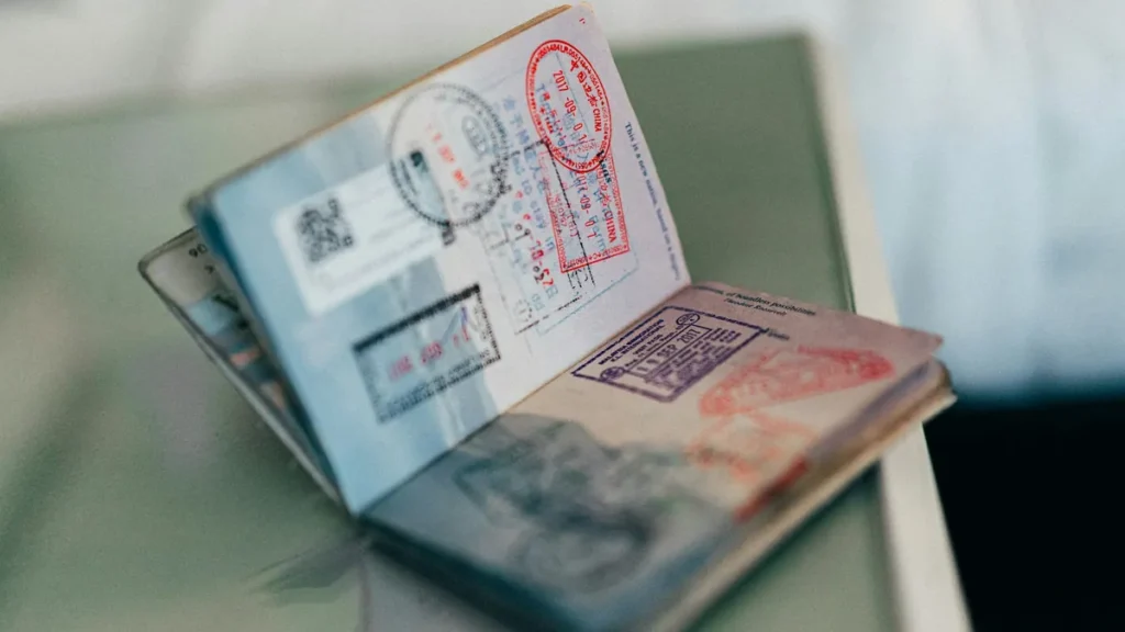 Open passport with entry stamps and visas, representing dependents' residency papers